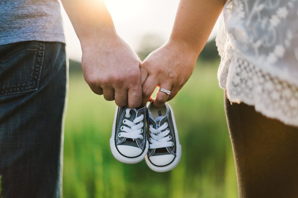 Parents holding their child's shoes, planning, 529 plan