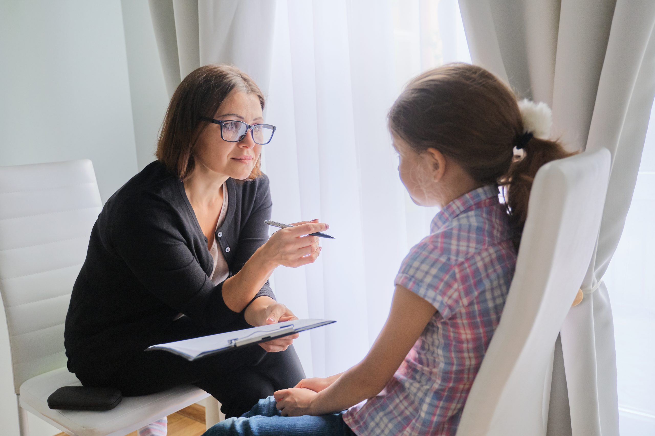 Talking girl and woman corporate trustee in office near window